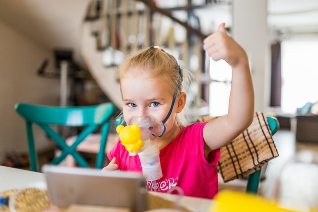 Meisje met allergisch astma gebruikend inhalator en tonend ok. Premium Foto