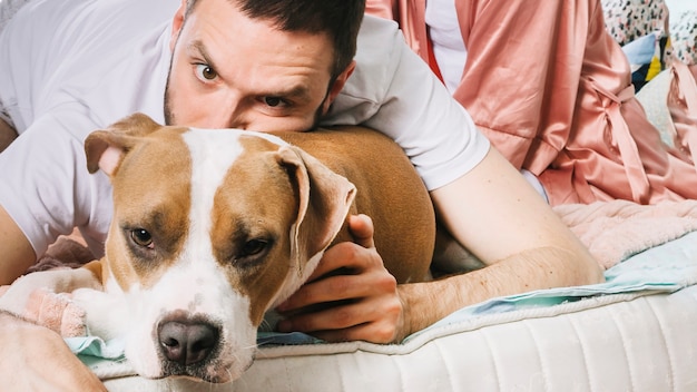 Mens met hond in bed Gratis Foto