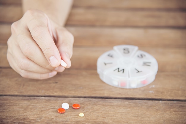 Mensen bereiden dagelijks medicijntablet in pillendoosje Gratis Foto