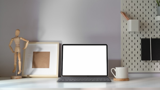 Mockup-tablet met slim toetsenbord op minimale werkruimtetafel. Premium Foto