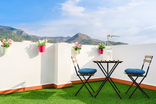 Mooi wit terras met stoelen en een koffietafel met uitzicht op de mediterrane mountai Premium Foto