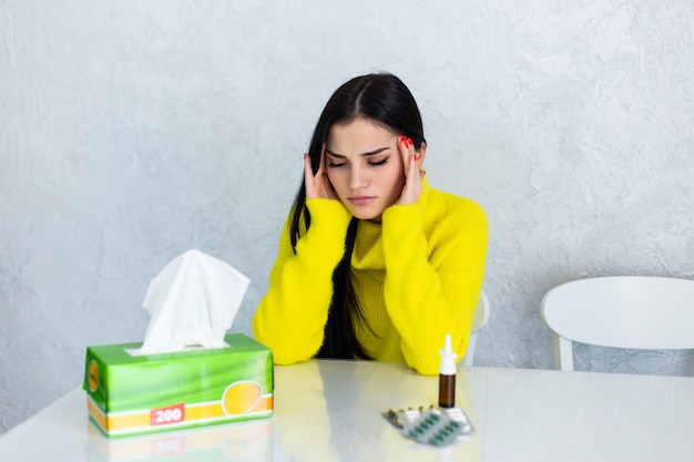 Onder het weer. zieke jonge vrouw die zich slecht voelt en haar neus