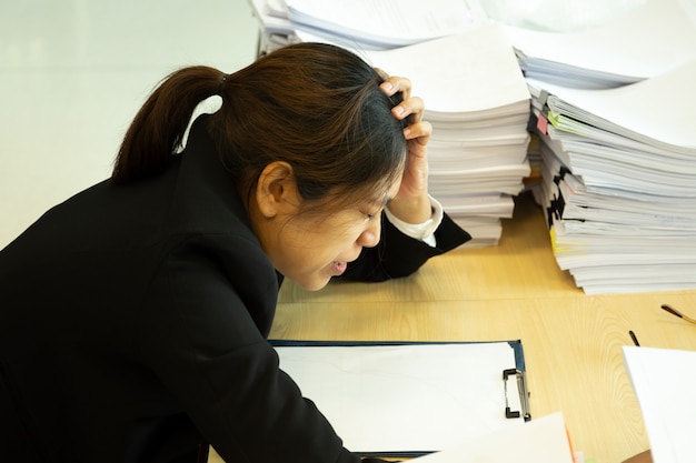 Onderneemster rustende handen op hoofd met ogen dicht bij het werkbureau in bureau. Premium Foto