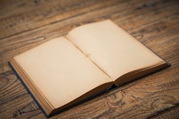 Oud boek open op een houten tafel Gratis Foto