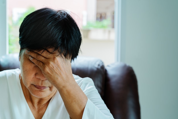 Oude vrouw die aan hoofdpijn, spanning, migraine, het concept van het gezondheidsprobleem lijden Premium Foto