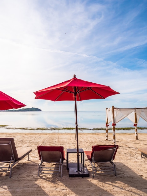 Paraplu en stoel op het tropische strand zee en de oceaan Gratis Foto