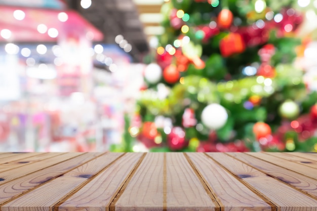 Perspectief lege houten tafel en kerstboom decoratie achtergrond wazig