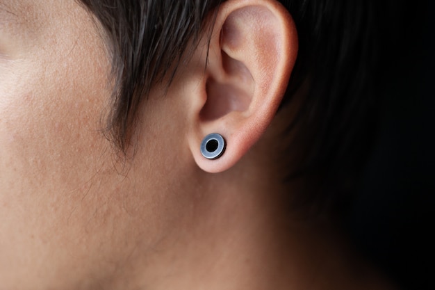 Piercing in het oor, tunnels de oren van een jonge man levensstijl | Premium Foto