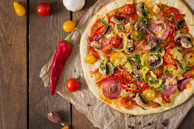 Pizza met salami, tomaat, kaas en champignons | Gratis Foto