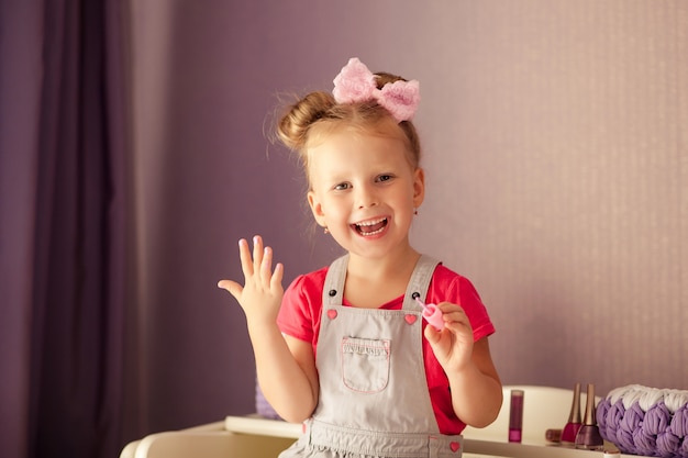 Flikkeren wetgeving Rechtmatig Portret van een gelukkig schattig meisje 3-4 jaar oud, een kind schildert  nagels | Premium Foto