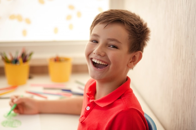 Primitief pomp bekennen Portret van een gelukkige jongen van 9-10 jaar oud. het kind tekent. |  Premium Foto
