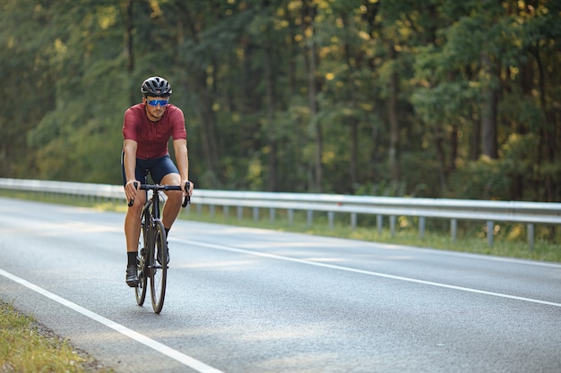 noodzaak Misverstand streepje Professionele wielrenner zwarte fiets rijden op asfaltweg tussen de groene  natuur. | Premium Foto