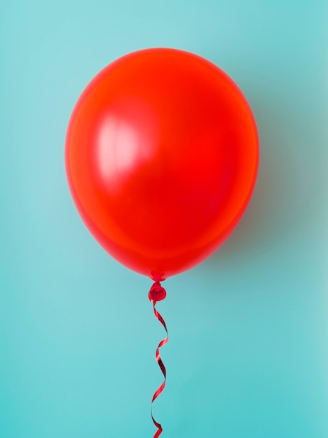 Rode ballon op blauwe achtergrond Gratis Foto