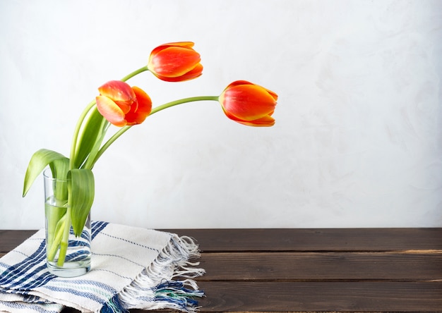 Rode tulpen in glazen vaas op tafel Gratis Foto