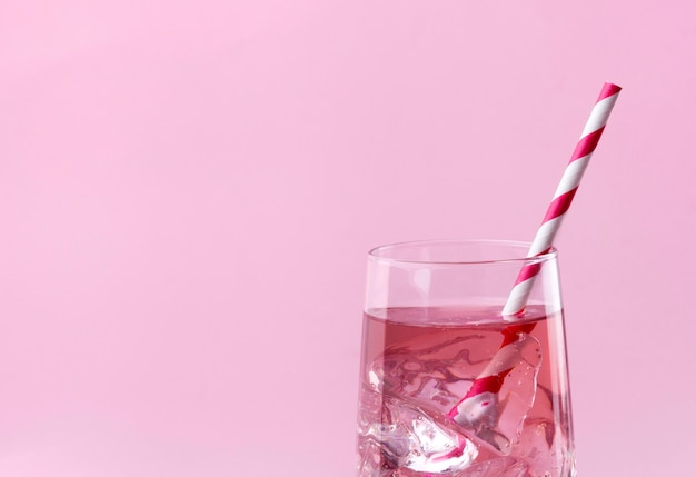 Roze roos cocktail op een roze tafel met gestreepte roze stro