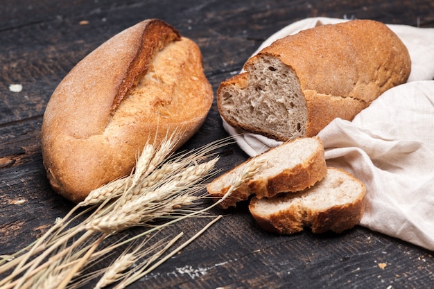 Rustiek brood op houten tafel. donkere houten achtergrond Gratis Foto