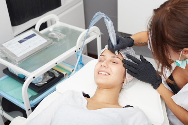 Schoonheidsspecialist brengt permanente make-up aan op wenkbrauwen Premium Foto