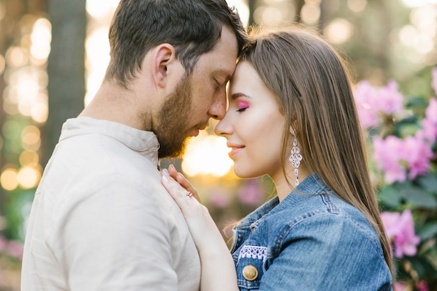 Sensueel jong koppel geniet teder warm aangenaam vriendelijk moment van liefde met romantische date, aanhankelijke mooie man en vrouw aanraken voorhoofd strelen elkaar liefhebbend in de natuurlente, Premium Foto