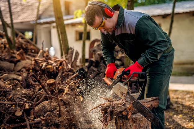 Sluiten foto van houthakker man in uniform en bescherming bezig met een