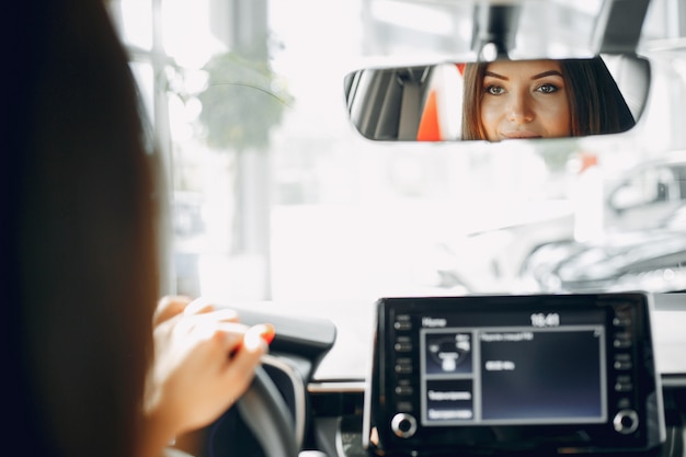 Stijlvolle en elegante vrouw in een autosalon Gratis Foto