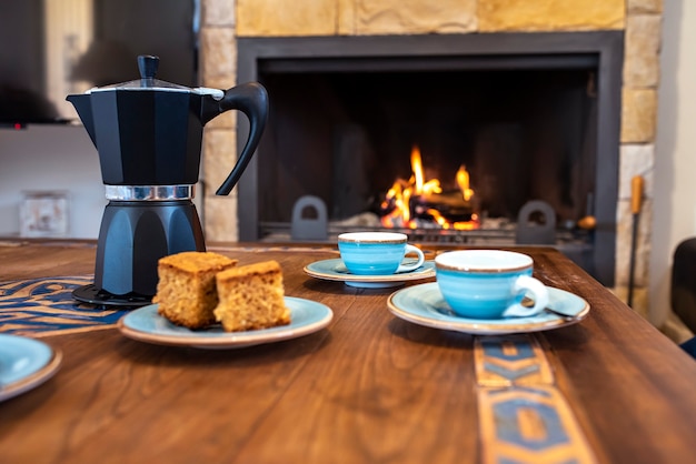 Tafel met kopjes koffiepot en een open haard Premium Foto