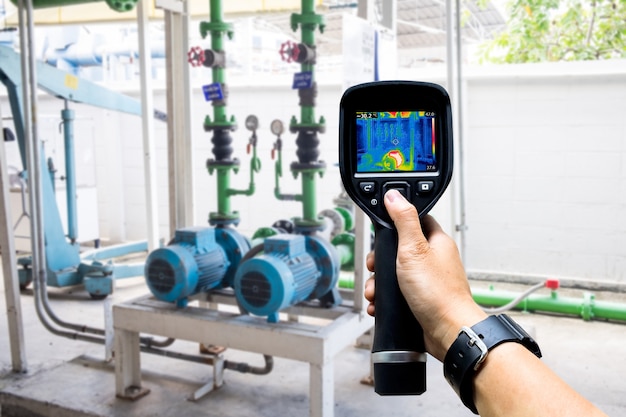 Technicus gebruikt warmtebeeldcamera om de temperatuur in de fabriek te controleren Premium Foto