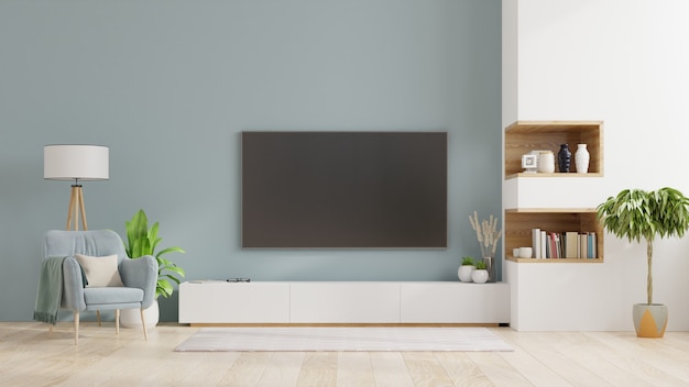 tv op kabinet in moderne woonkamer interieur van een lichte woonkamer met fauteuil op lege blauwe muur premium foto