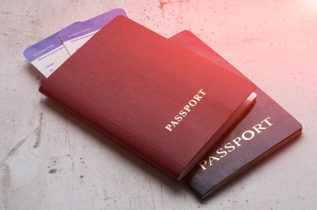 Twee reizigerspaspoorten rood en blauw met instapkaarten voor het vliegtuig. Premium Foto