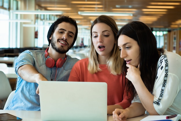 Universitaire studenten die laptop in universitaire bibliotheek met behulp van. Premium Foto
