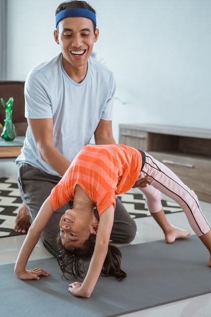 schors Minst Verhogen Vader die zijn dochter bijstaat om thuis uit te rekken. kind trainen met  ouder gymnastiek doen | Premium Foto