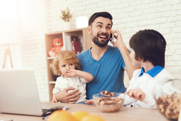 Vader is bezig met het opvoeden van kinderen tijdens het werk Premium Foto
