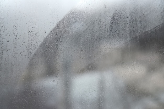 Vensterglas met condensaat of stoom na zware regen, textuur of achtergrond Premium Foto
