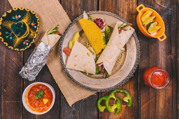 Verscheidenheid van mexicaans eten met hoed op houten tafel Gratis Foto