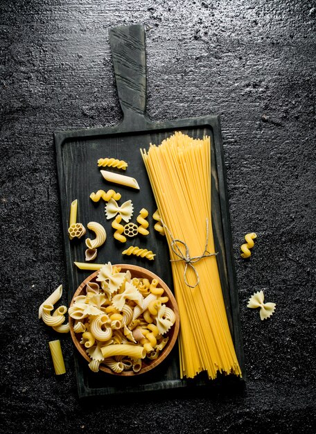 Verschillende Soorten Droge Pasta Op Een Snijplank En Een Kom Op Zwarte