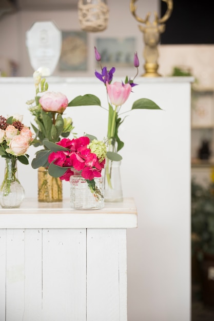 Verschillende soorten vazen met kleurrijke bloemen op tafel in de