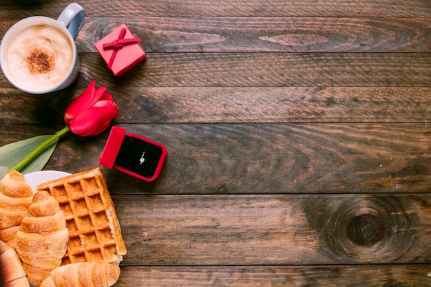 Verse bloem, bakker, ring in geschenkverpakking en een kopje drank Gratis Foto