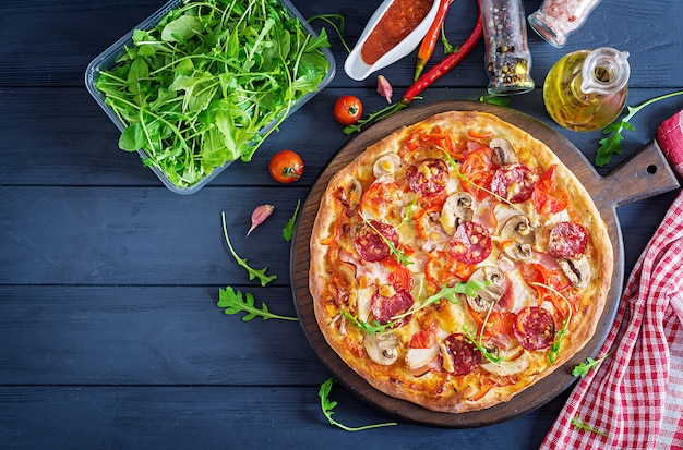 Verse Italiaanse Pizza Met Kipfilet Champignons Ham Salami Tomaten Kaas Op Een Zwarte Achtergrond Premium Foto