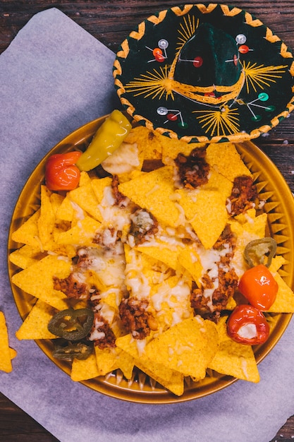 Versierde smakelijke mexicaanse nachos in plaat met mexicaanse hoed op