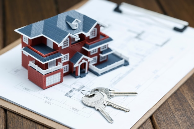 Villa huis model, sleutel en tekening op retro desktop (onroerend goed verkoop concept) Gratis Foto
