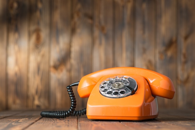 twijfel toenemen Een evenement Vintage oranje telefoon op een houten tafel | Premium Foto