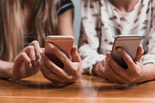 Vooraanzicht handen typen berichten op telefoons Gratis Foto