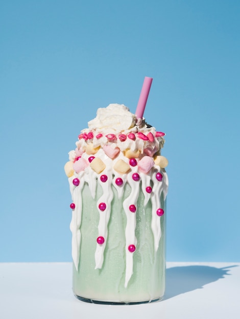 Vooraanzicht van heerlijke milkshake met blauwe achtergrond Gratis Foto
