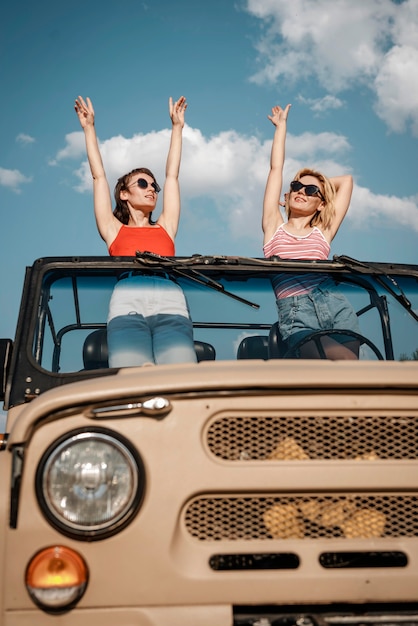 Vooraanzicht twee vrouwen die plezier hebben tijdens het reizen de auto Gratis Foto