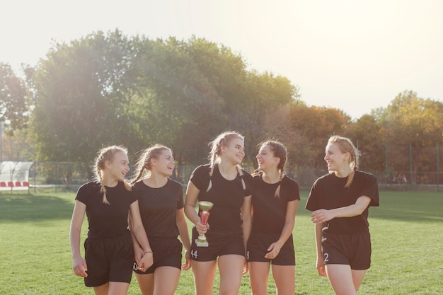 Vooraanzicht vrouwelijke voetballers met een trofee Gratis Foto
