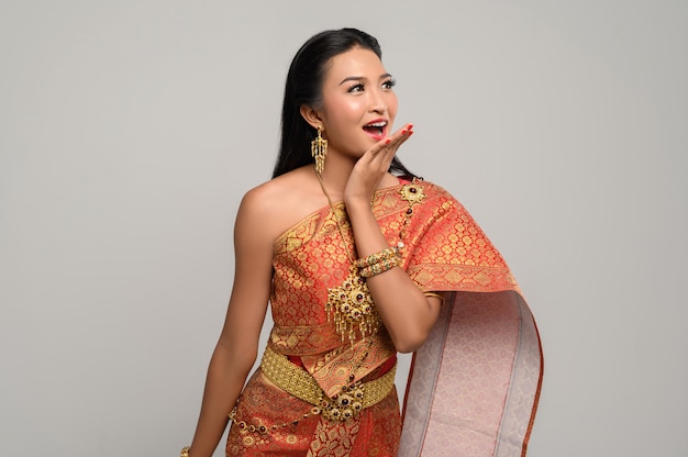 Vrouw die thaise kleding draagt die een handsymbool maakte Gratis Foto