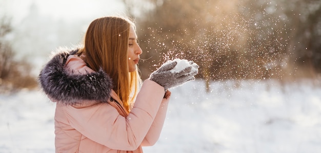 Vrouwen blazende sneeuw van handen Gratis Foto