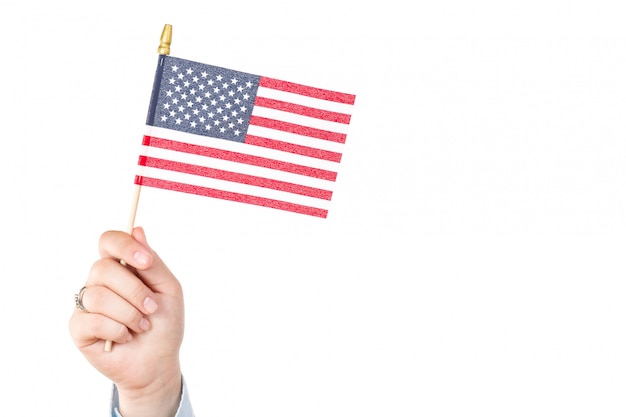 Vrouwenhand die amerikaanse vlag van de vs met sterren en strepen houden op wit worden geïsoleerd dat Premium Foto