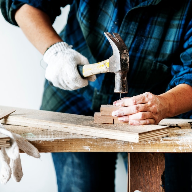 Vrouwentimmerman die hamer duwende spijker op een hout gebruiken