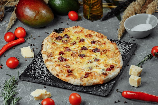 Warme vier kazen heerlijke rustieke zelfgemaakte amerikaanse pizza met korst op zwarte tafel | Premium Foto