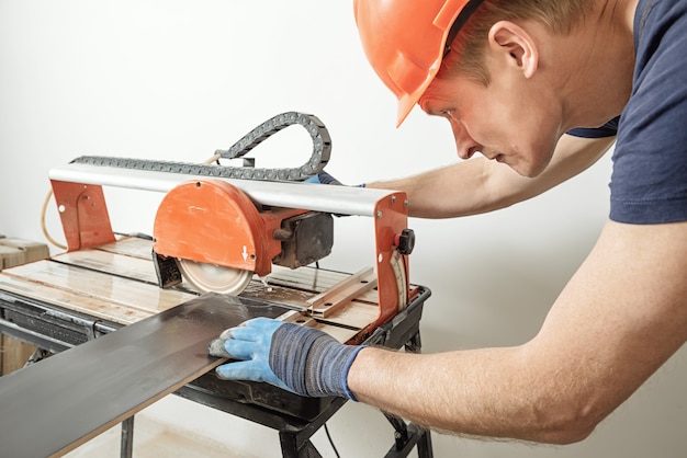 vernieuwen verdwijnen Bejaarden Werknemer een keramische tegel snijden op een natte snijder zag machine |  Premium Foto